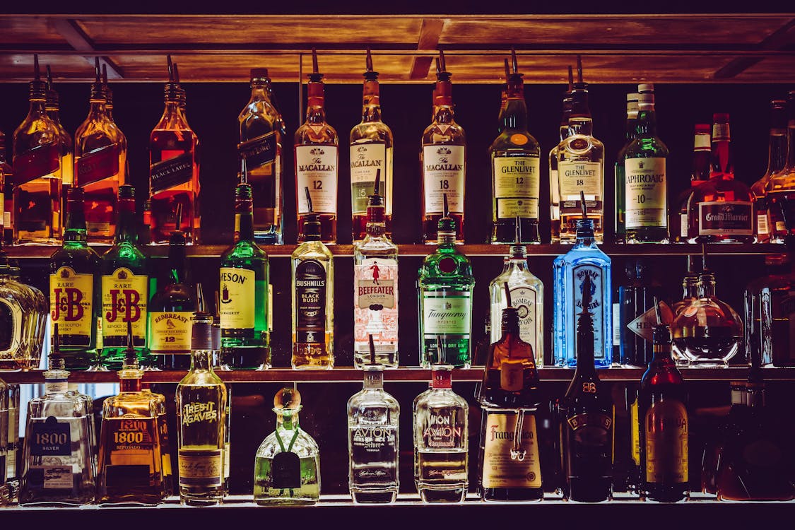 Selección de botellas de vino tinto expuestas en estantería de madera para elegir como regalo del Día del Padre