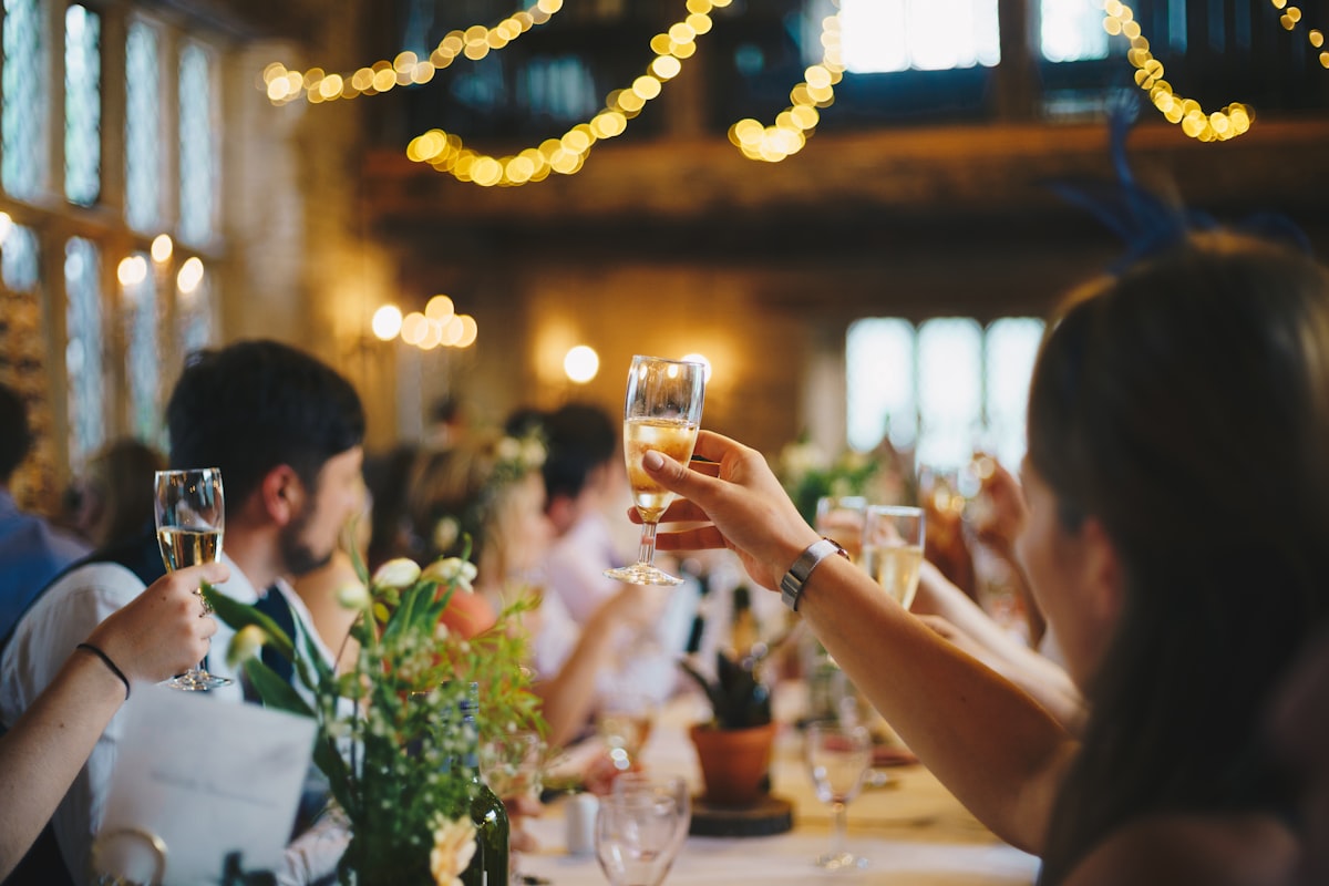 Dos personas brindando con copas de vino rosado en una celebración familiar